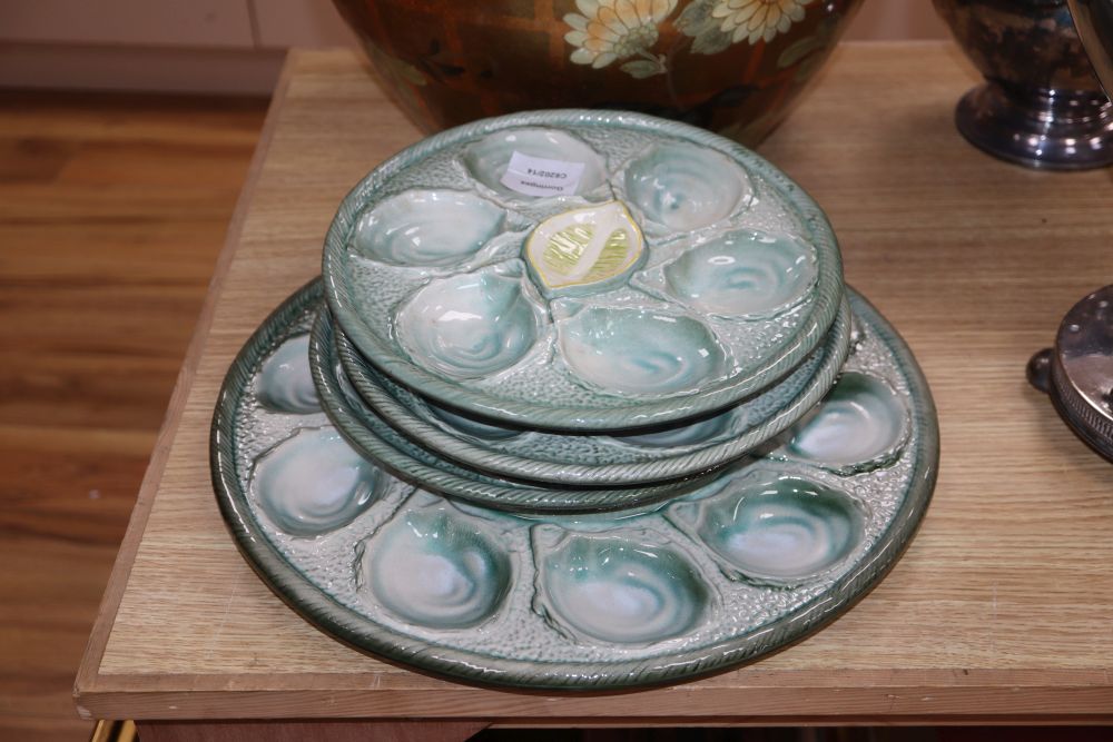 A set of four pottery oyster dishes, and a platter, the platter diameter 37cm